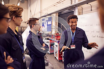Male Tutor By Whiteboard With Students Teaching Auto Mechanic Apprenticeship At College Stock Photo
