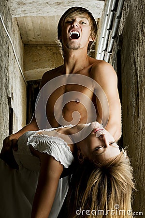Male vampire is going to bite a young woman Stock Photo