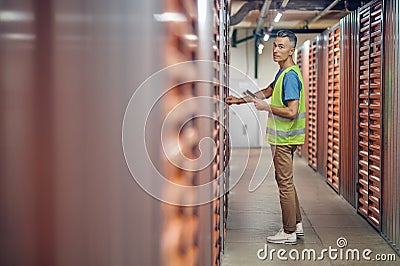 Male warehouse worker checking garage lock Stock Photo