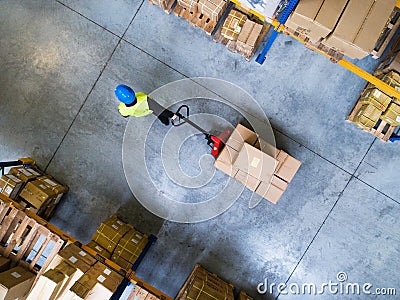 Male warehouse worker pulling a pallet truck. Stock Photo