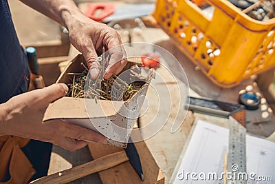 Male worker choosing the right metal bolts Stock Photo