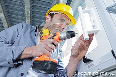 Male worker drill window Stock Photo