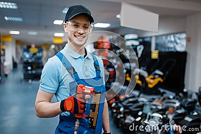 Male worker holds pneumatic nailer in tool store Stock Photo