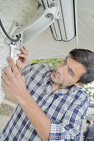 male worker installing video camera Stock Photo