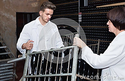 Male worker transporting wine bottles to storage Stock Photo