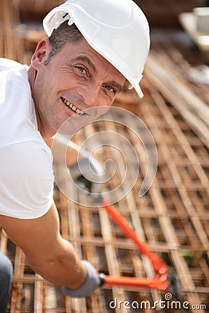 male worker using bolt croppers on metal rebars Stock Photo