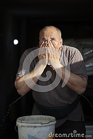 Male worker washes his face Stock Photo