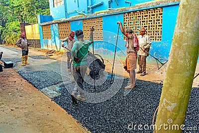 Male workers build road with asphalt Editorial Stock Photo