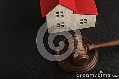 Mallet of judge and model house on black background. Real estate auction. Confiscated housing. Resolving property disputes Stock Photo