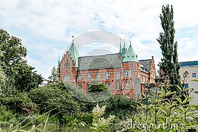 MalmÃ¶, Sweden - July 19, 2019: The old castle like building is housing the city library. It stands in the middle of a green park Editorial Stock Photo