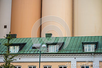 Tall grain silo behind roof apartments in an old building.. Editorial Stock Photo