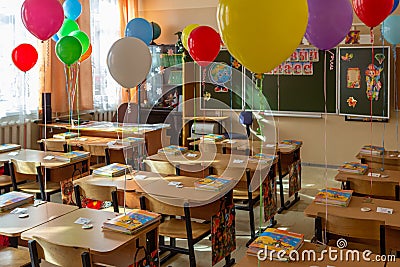 Classroom decorated for September 1st: colorful balloons over the desks, blur and grain effect. Editorial Stock Photo