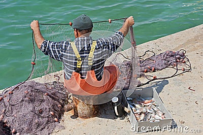 Maltese fisherman examining his nets Editorial Stock Photo