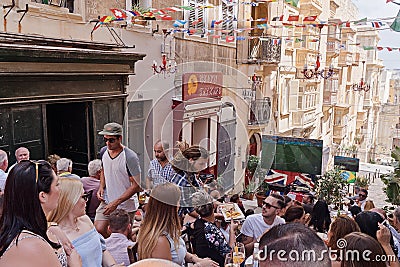 Maltese people fans watch football match on Valletta street Editorial Stock Photo