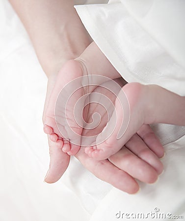 Mama`s hand and baby`s feet Stock Photo