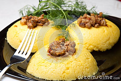 Mamaliga with cracklings on a plate. Stock Photo