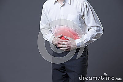 Man with abdominal pain, stomach ache on gray background Stock Photo