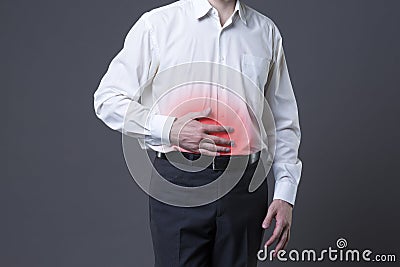 Man with abdominal pain, stomach ache on gray background Stock Photo