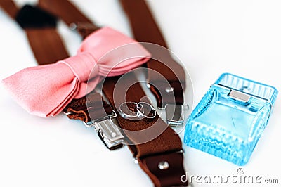 Man accessories. Wedding rings, bow tie, parfume, suspenders Stock Photo