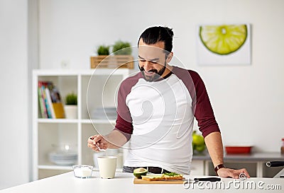 Man adding sugar to cup for breakfast at home Stock Photo