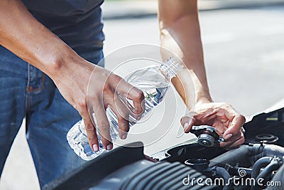 Man adding water to car radiator Stock Photo