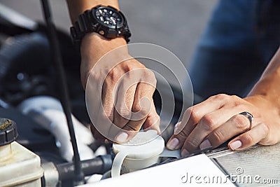 Man adding water to car radiator Stock Photo