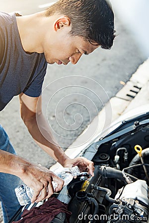 Man adding water to car radiator Stock Photo