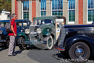 Man admiring vintage cars at a classic car show in Motueka High Street in front of the museum Editorial Stock Photo