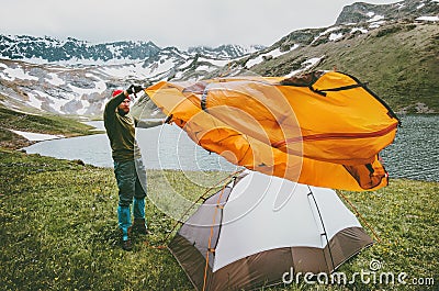 Man adventurer pitching tent camping gear outdoor Stock Photo