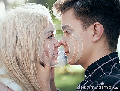 A man affectionately call looks at woman, guy and girl are worth close, touching the tips noses. Concept of teenage love and first Stock Photo