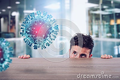 Man is afraid of the covid19 virus and he is hidden rear a desk Stock Photo