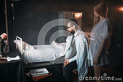 Man against empty hospital bed, soul of dead woman Stock Photo