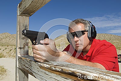 Man Aiming Hand Gun At Firing Range Stock Photo