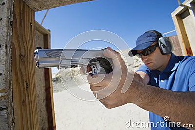 Man Aiming Hand Gun At Firing Range Stock Photo