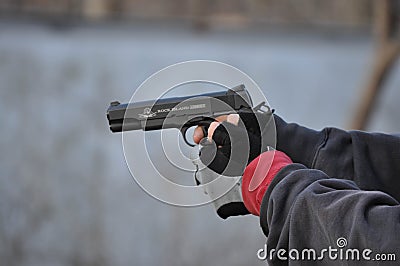 Man Aiming and Shooting .45 Caliber 1911 Hand Gun with Gloves Editorial Stock Photo