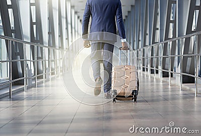 Man at airport moving to terminal gate for business trip, back view Stock Photo