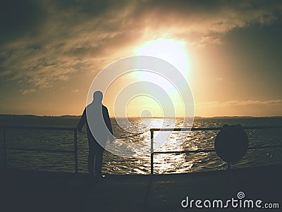 Man alone stay on sea bridge and watch the amazing sunrise Stock Photo
