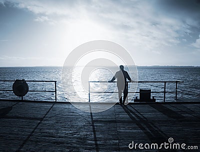 Man alone stay on sea bridge and watch the amazing sunrise Stock Photo