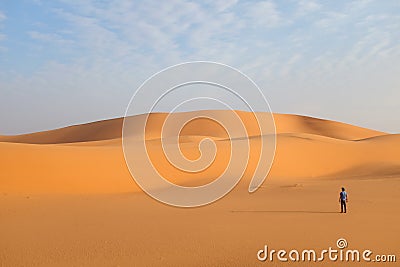 A man alone in a vast desert landscape Stock Photo