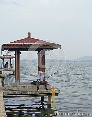 Man is angling fish on lake in Wuhan, China Editorial Stock Photo