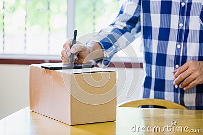 Man appending signature sign on smartphone for sending boxes in post office Stock Photo