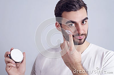 Man applying face cream on cheeks Stock Photo