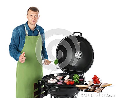 Man in apron cooking on barbecue grill Stock Photo