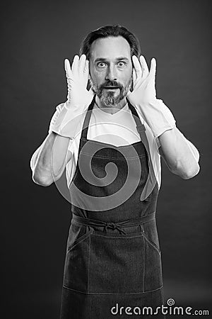 Man in apron with gloves cleaning agent. Cleaning day today. Bearded guy cleaning home. On guard of cleanliness and Stock Photo