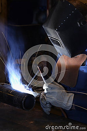 A professional welder joining two pieces of metal together Editorial Stock Photo