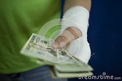 A man with an arm in a cast counted out money from the cost and expenses of emergency medical care at the hospital Stock Photo