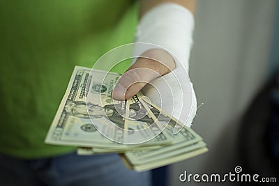 A man with an arm in a cast counted out money from the cost and expenses of emergency medical care at the hospital Stock Photo