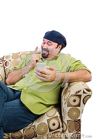 Man in armchair with mobile wagging finger Stock Photo