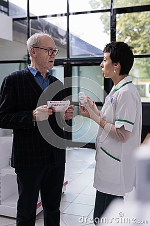 Man asking chemist to find prescripted heart supplements analog Stock Photo