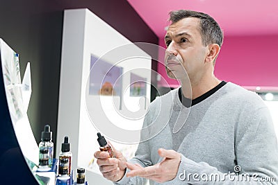Man asking for refund in e-cigarette shop Stock Photo